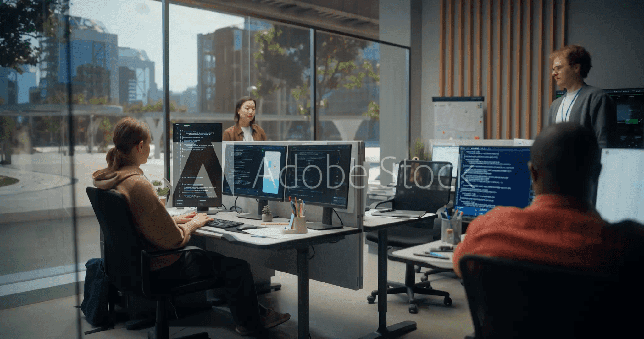 Team working at computers in a glass-walled office